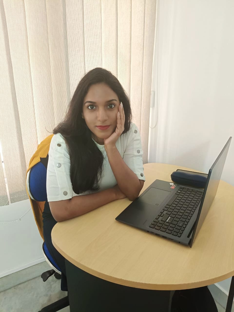 Anjana R. Mathew sitting at a laptop desk