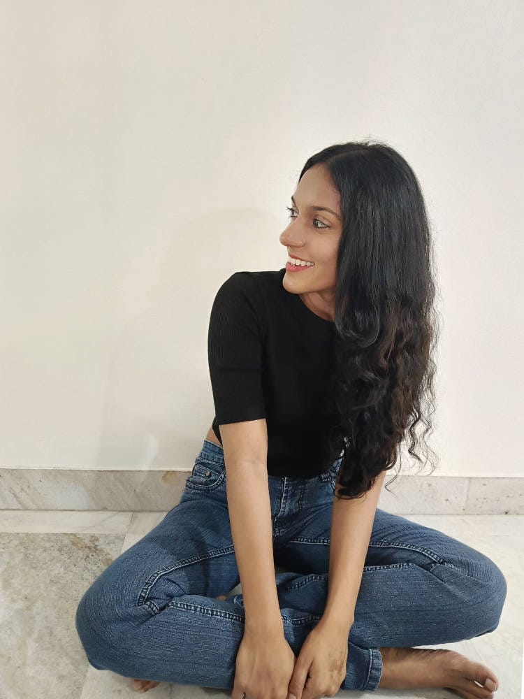 Anjana sitting on the floor and smiling